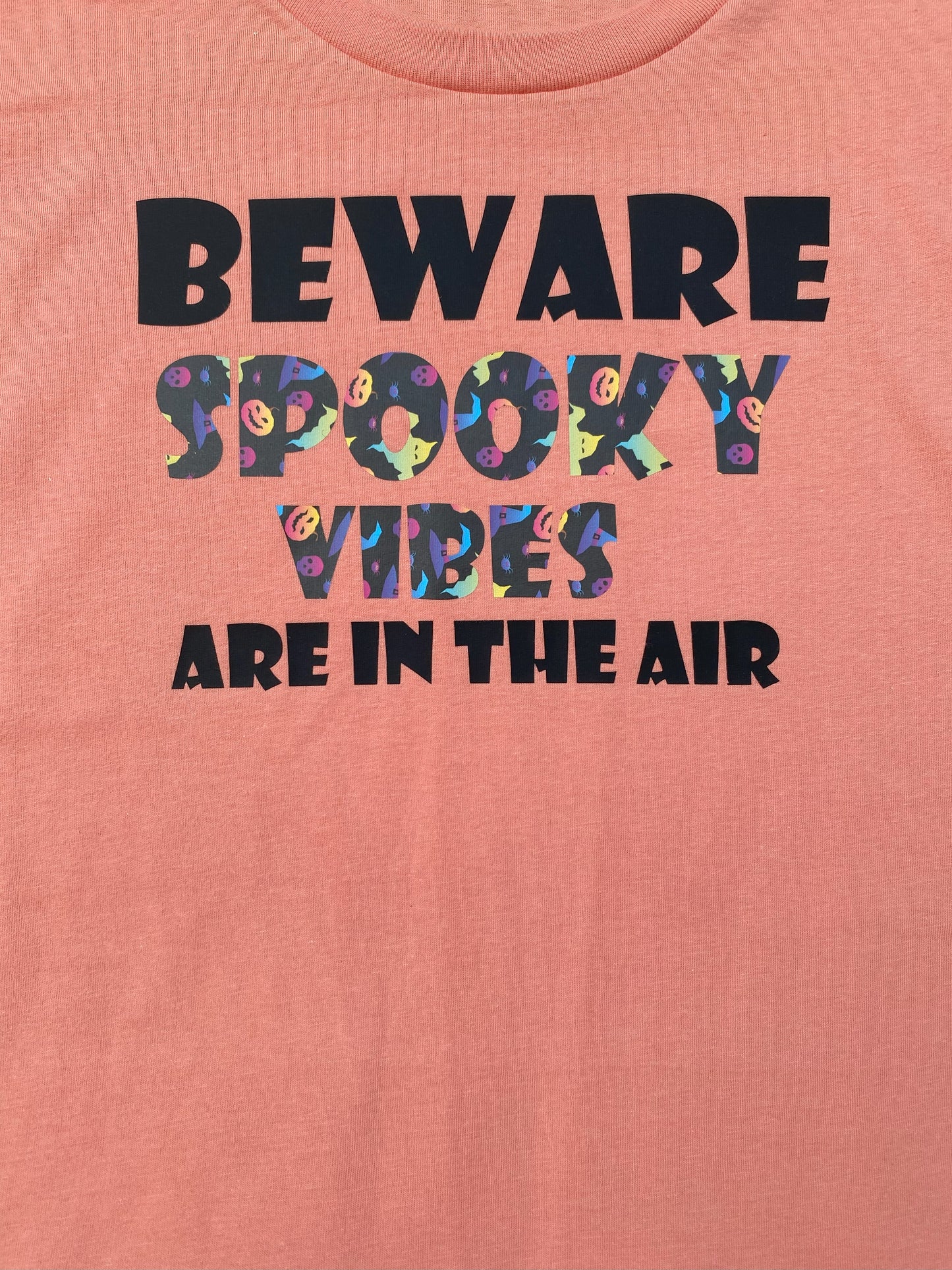 Grit City Rebel sunset orange unisex t-shirt with the phrase beware spooky vibes are in the air. Available in sizes small to 3xl.