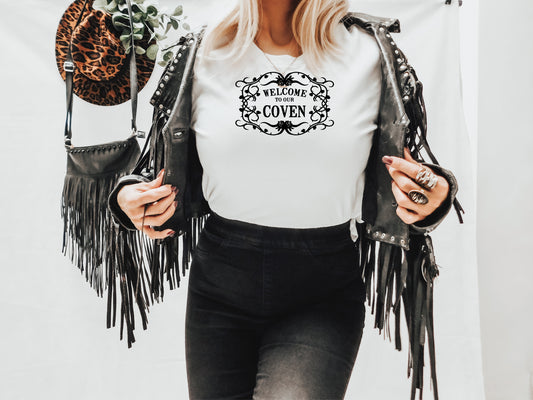 White unisex tshirt with Welcome to our Coven in blsvk surrounded by a black vine