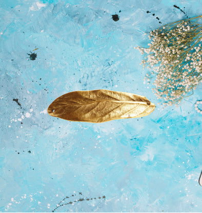 a leaf charm in antique gold. the charm has a slight curve to utilize as a bracelet spacer. the charm is approximatley 2 inches long