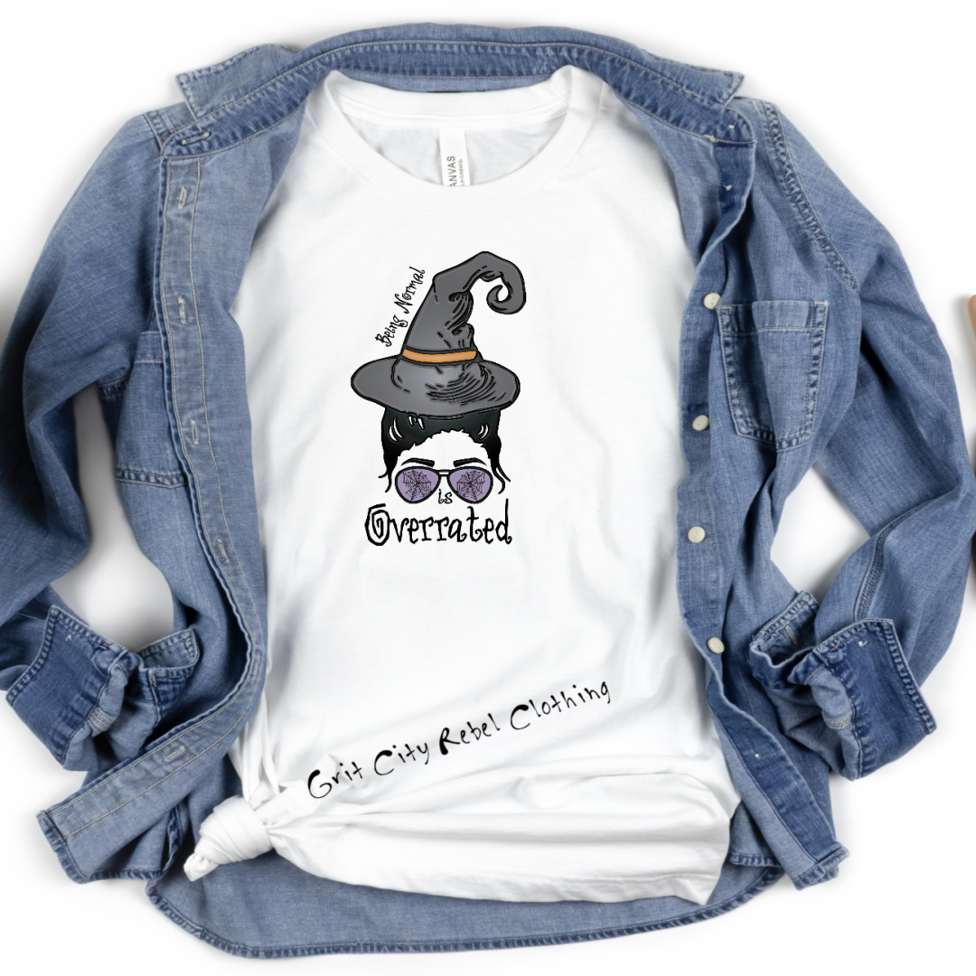 White short sleeve unisex fit T-Shirt with a witch face and hat that says Being Normal Is Overrated