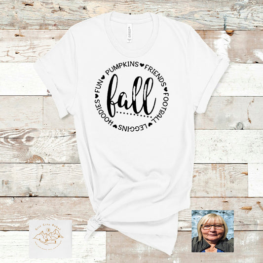 Fall with a circle of fall words in black writing on a white Tshirt Grit City Rebel sizing unisex sizes small medium large Xlarge 2X 3X