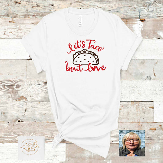 Let's Taco bout love in red writing and a black taco in the middle on a white unisex T-Shirt Grit City Rebel