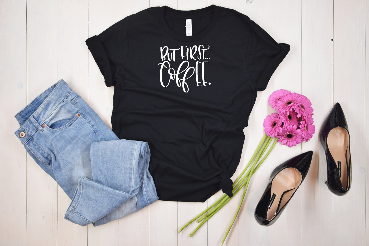 Black short sleeve unisex Tshirt with white writing and the saying But First Coffee
