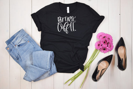 Black short sleeve unisex Tshirt with white writing and the saying But First Coffee
