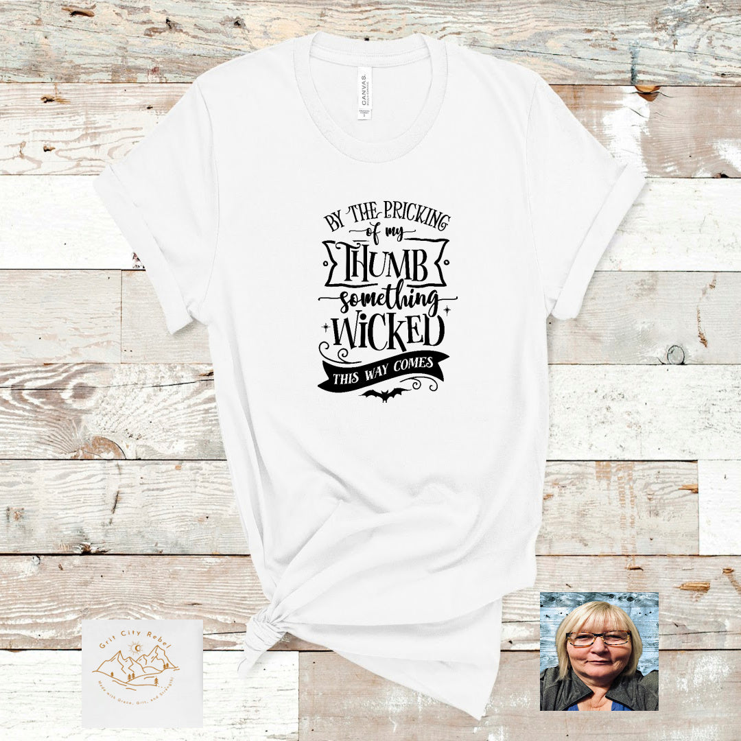 White unisex short sleeve Tshirt with the saying By the pricking of my thumb something wicked this way comes
