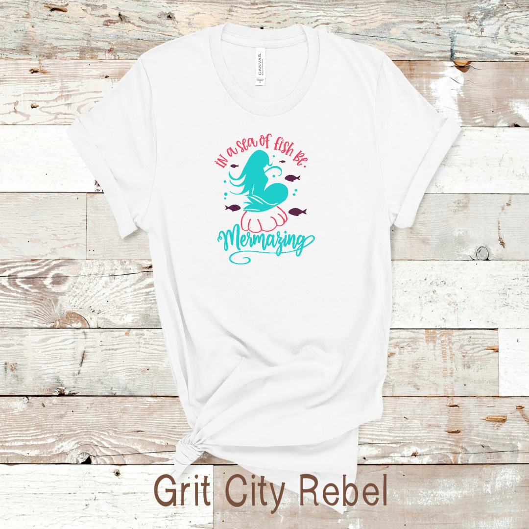 In a sea of fish be mermazing red and teal on a white Tshirt