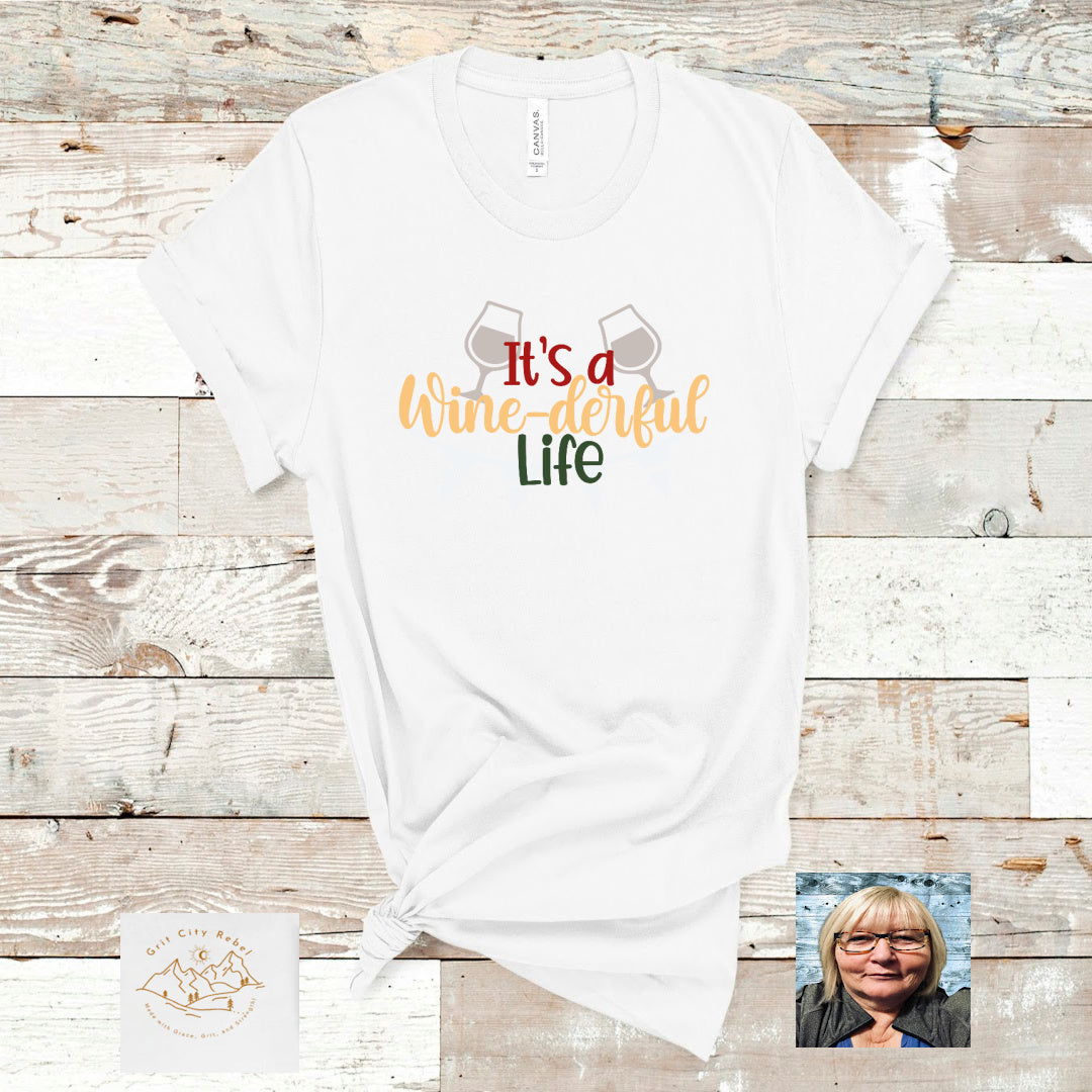 White T-Shirt with the saying "It's a wine derful life" in color writting.