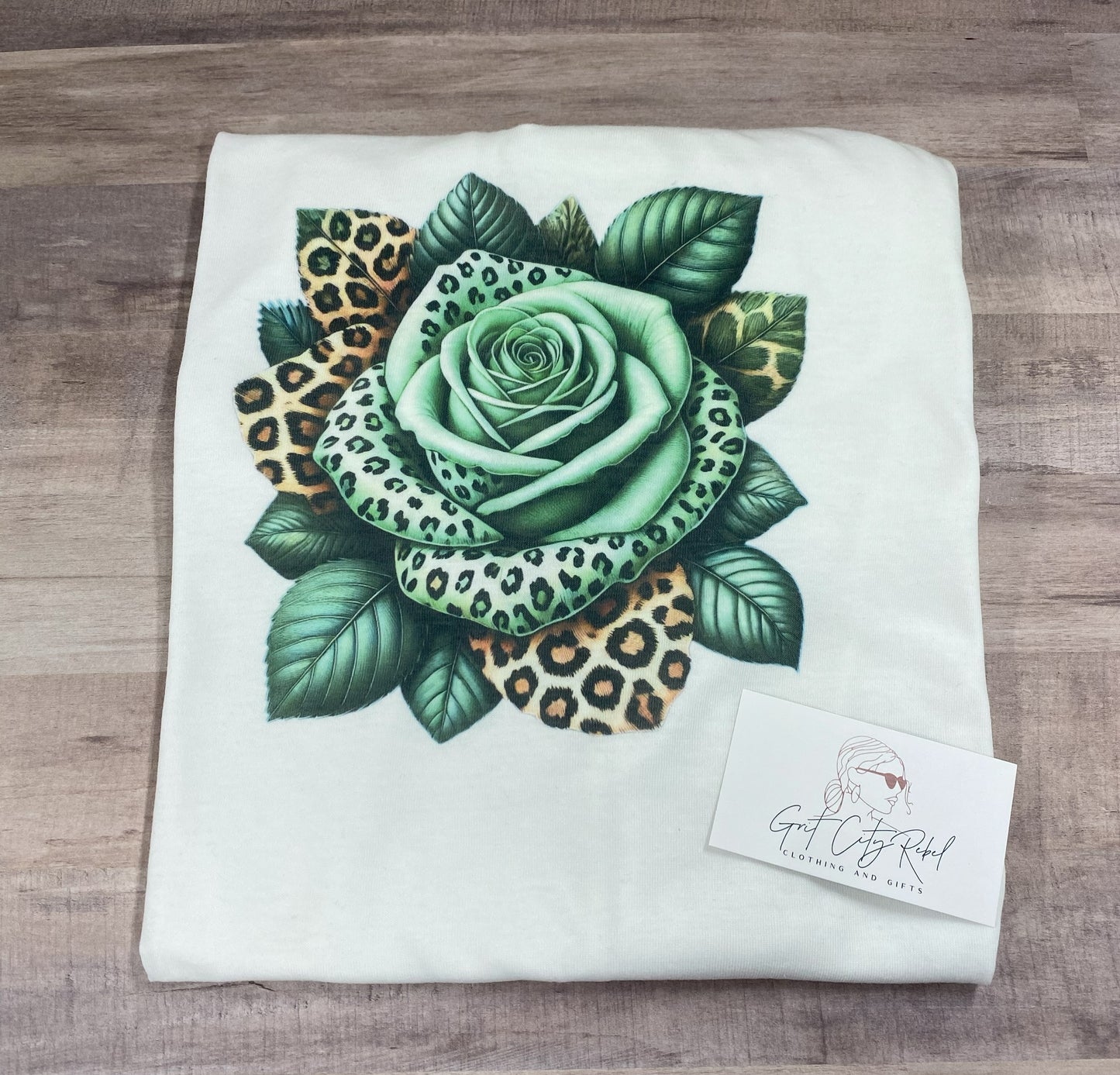 grit city rebel unisex white tshirt with a green and leopard print rose. sizes small to 3xl.