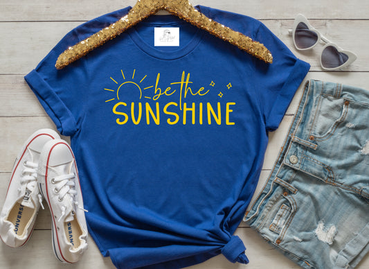 grit city rebel royal blue unisex short sleeve t-shirt with the phrase be the sunshine with the graphic representing the outline of a sun. Available in sizes small through 3xl. 