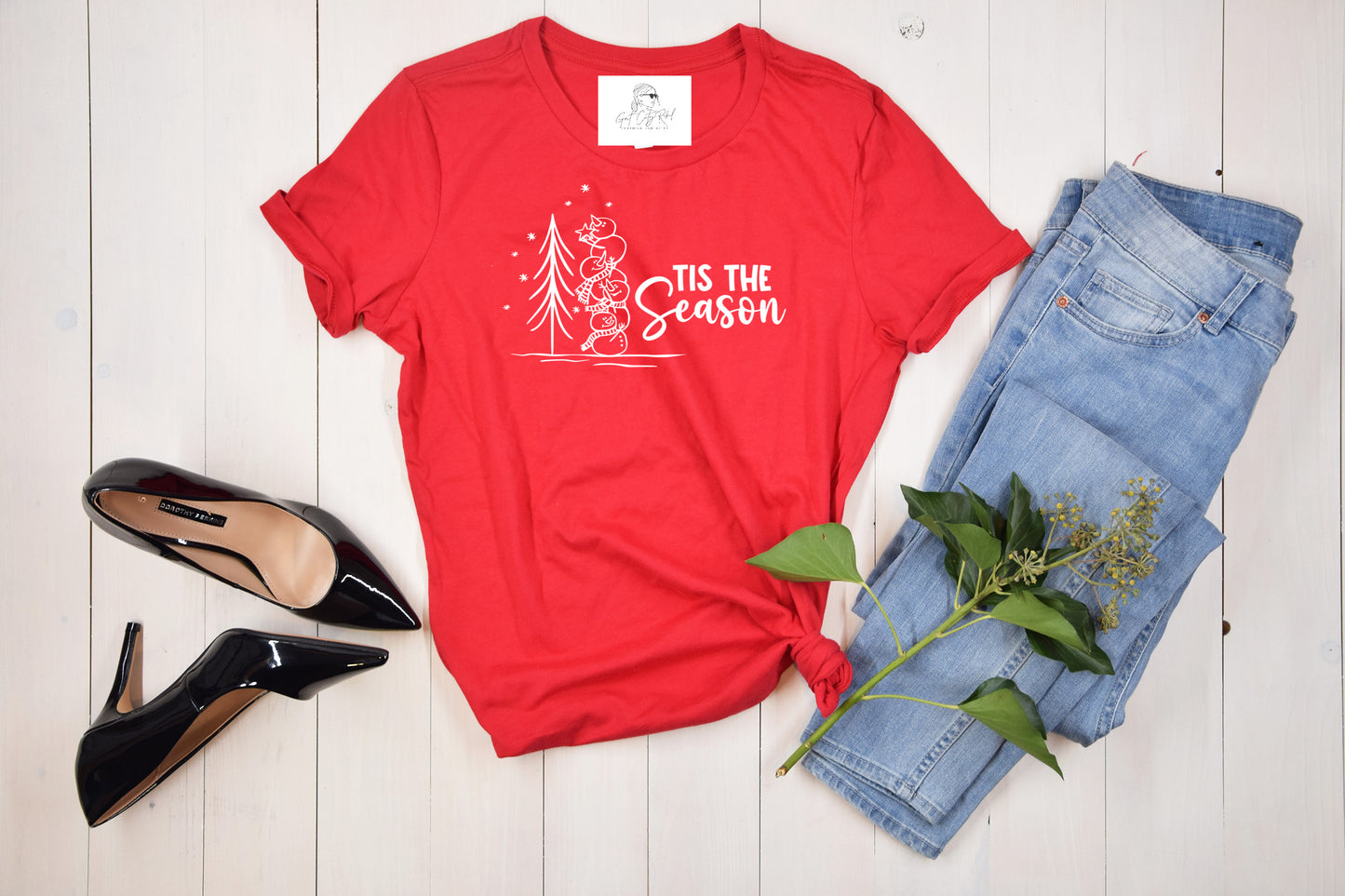 Grit city rebel clothing unisex red t-shirt with the phrase "tis the season" with a graphic of four snowmen stacked placing a star on an outdoor tree. available in sizes small to 3xl, crew or v-neck