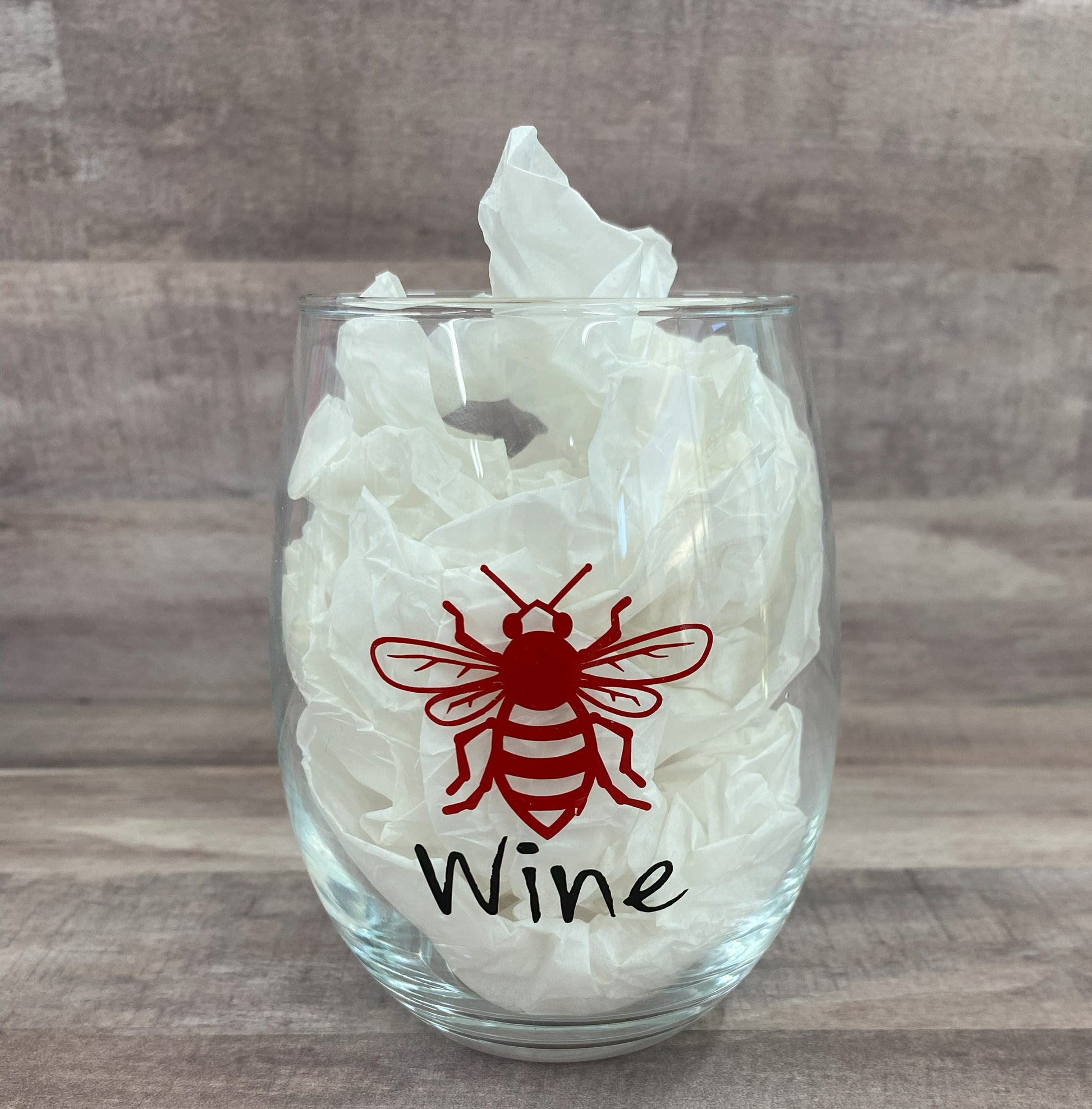 Stemless 15oz wine glass with a red bee outline and the phrase "wine" in black writing. Customizable. Designed by Grit City Rebel.