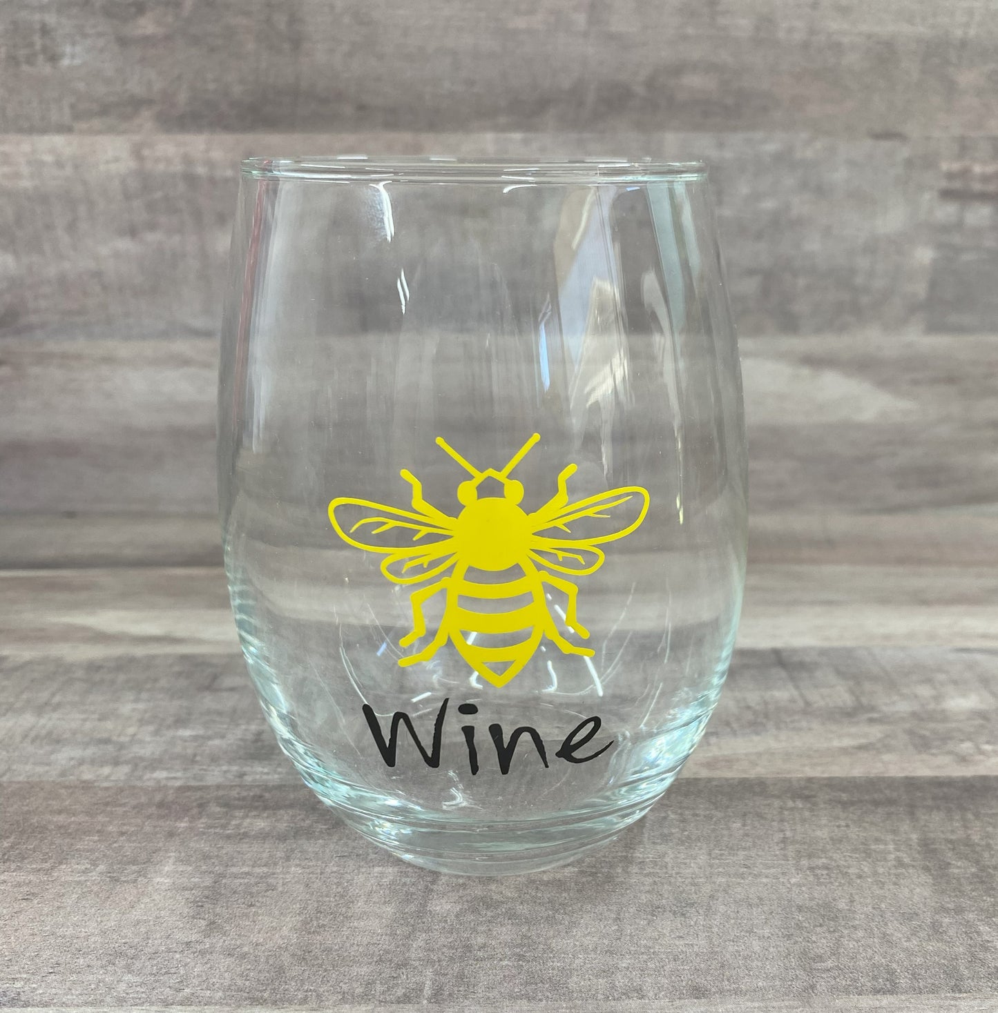 Stemless 15oz wine glass with the a bee outline in yellow with the word wine in black writing Customizable. Designed by Grit City Rebel.