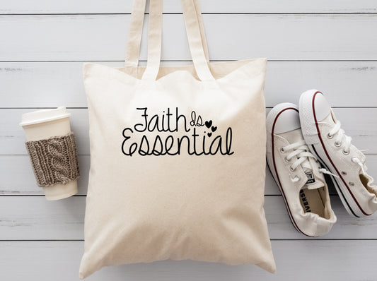cream colored cloth reusable tote bag with the saying Faithis essential 