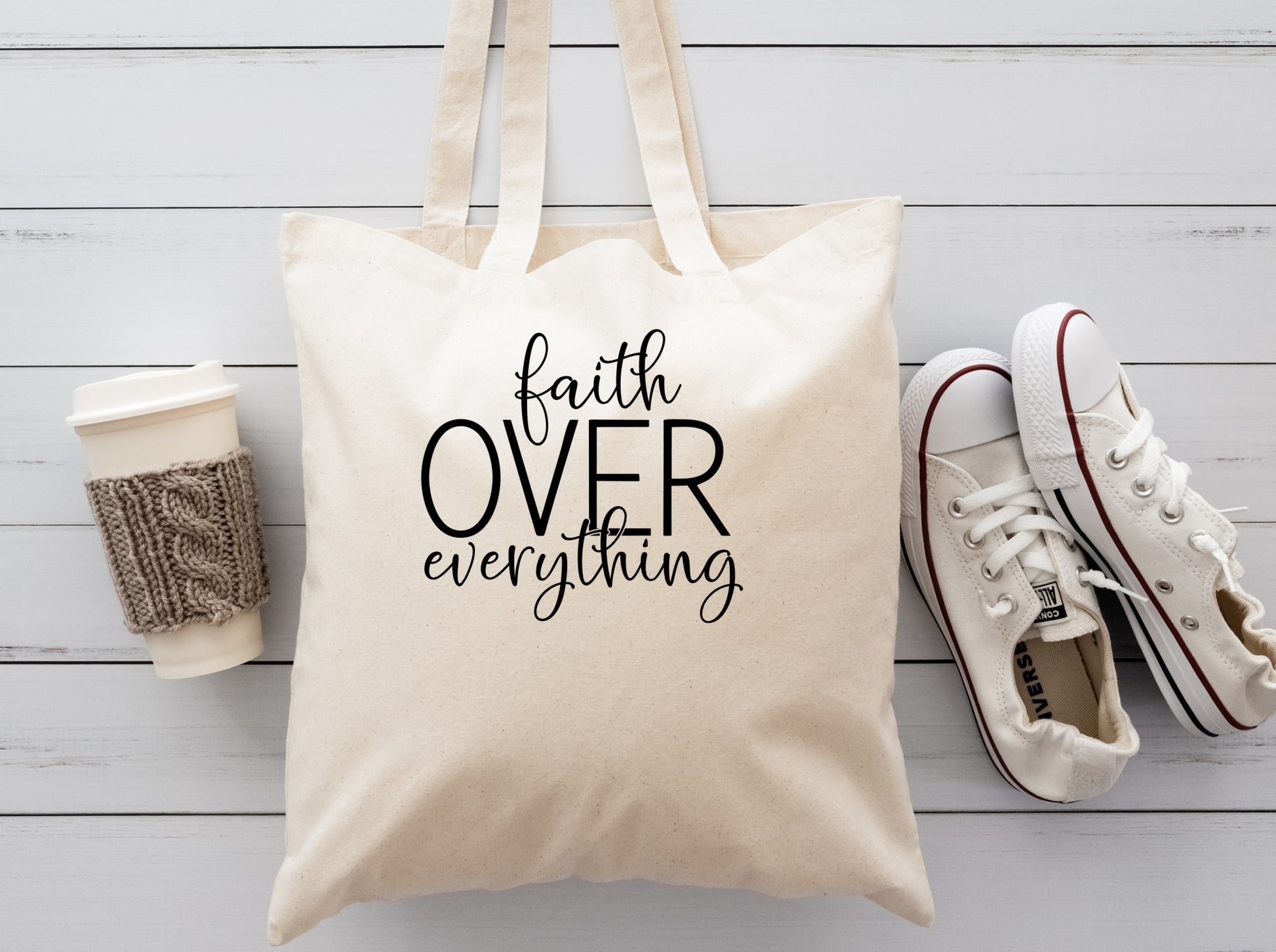 cream colored cloth reusable tote bag saying Faith over everything in black