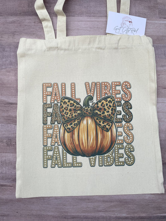 reusable cotton tote (not a flat bottom) with the phrase fall vibes repeated four times with a pumpkin with a leopard bow.  The size is approximately 15 by 15.  