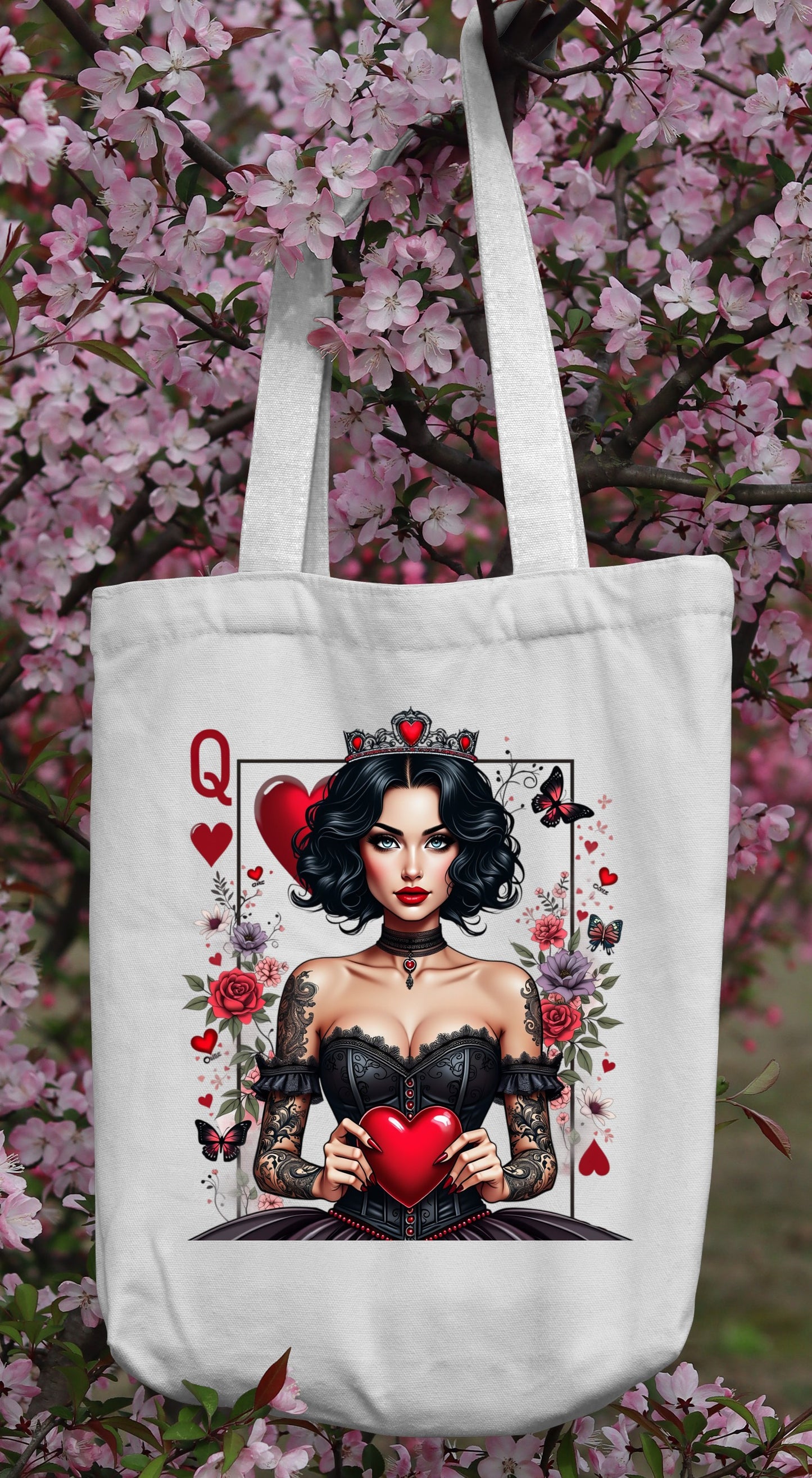 Tote bag with a Queen of Hearts design in front of cherry blossoms