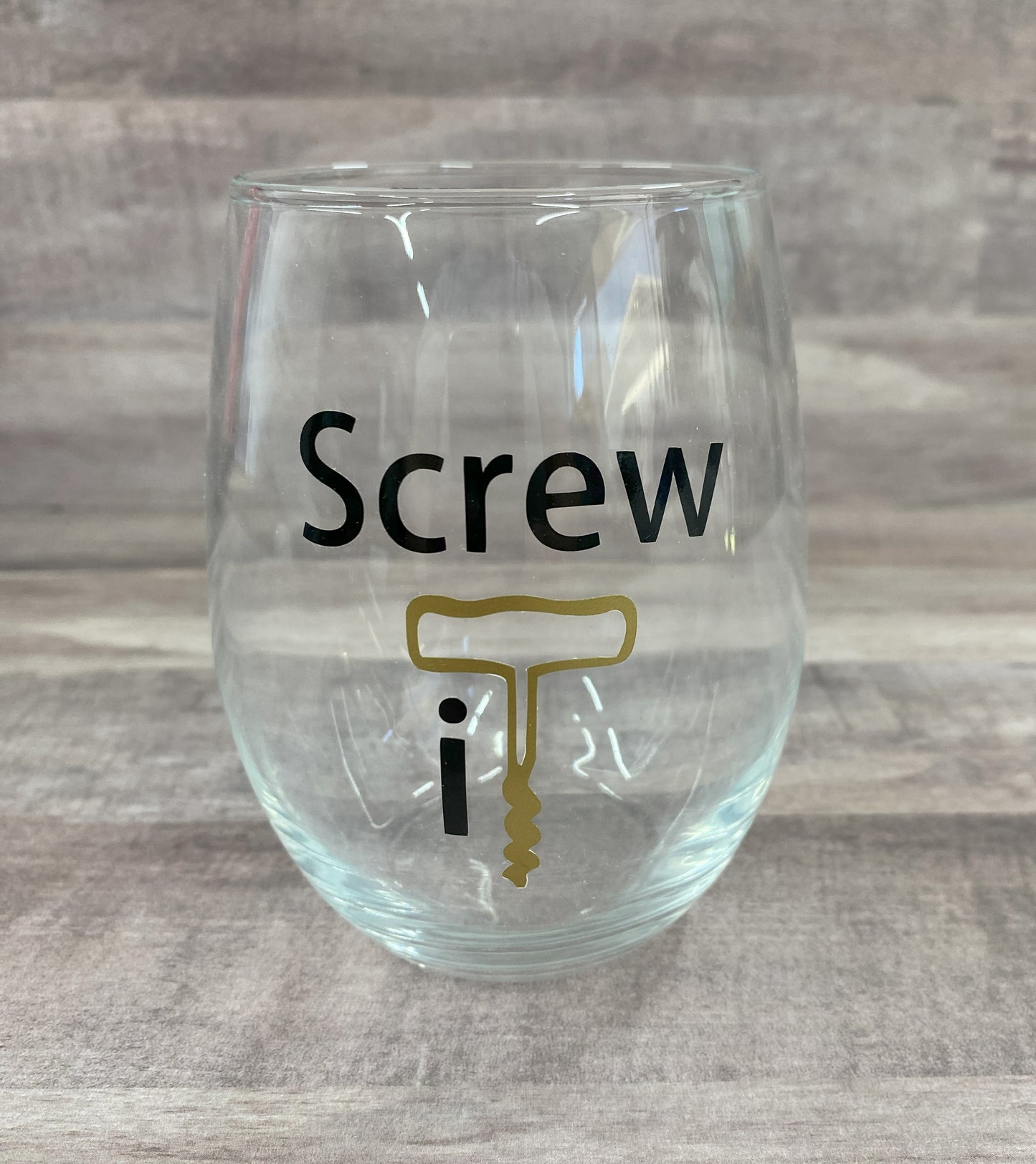 Stemless 15oz wine glass with the phrase screw it in black writing with the it as a graphic of a cork opener in gold Customizable. Designed by Grit City Rebel.