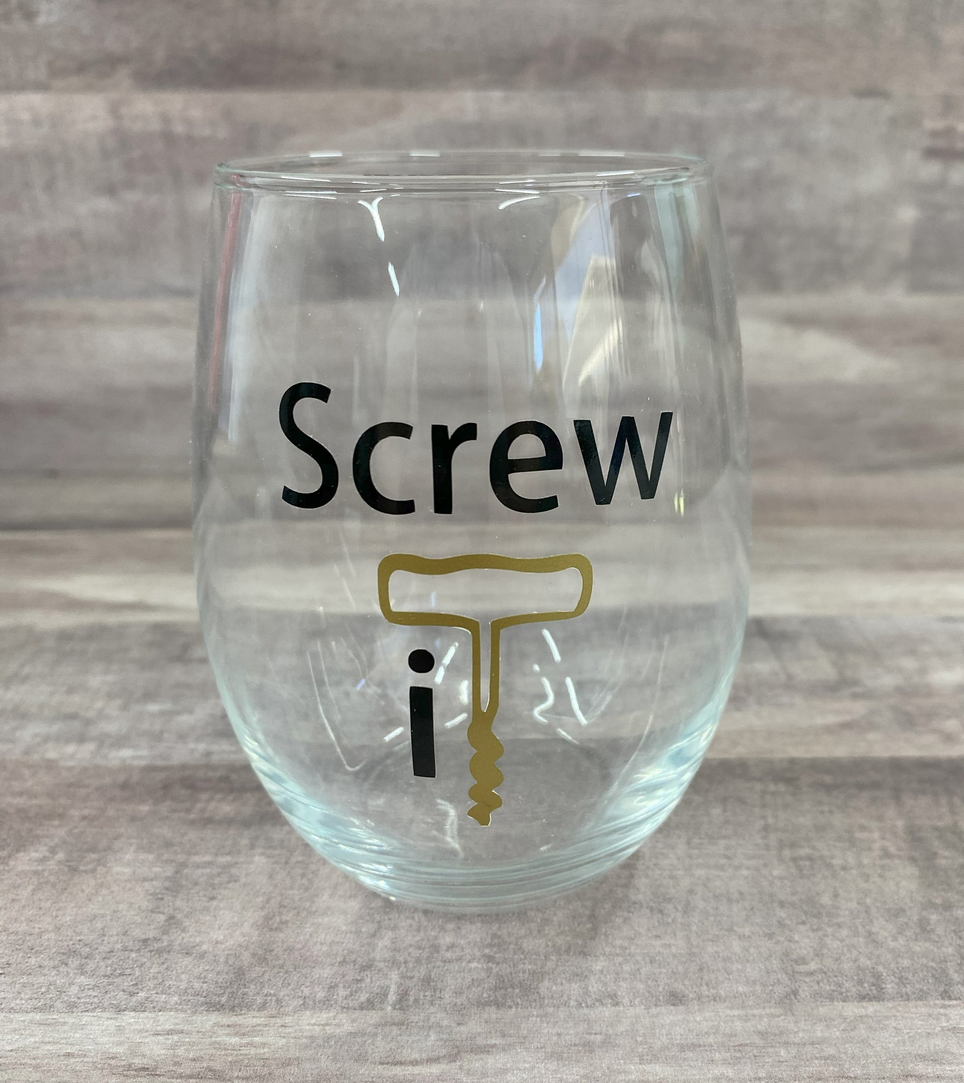 Stemless 15oz wine glass with the phrase screw it in black writing with the it as a graphic of a cork opener in gold Customizable. Designed by Grit City Rebel.