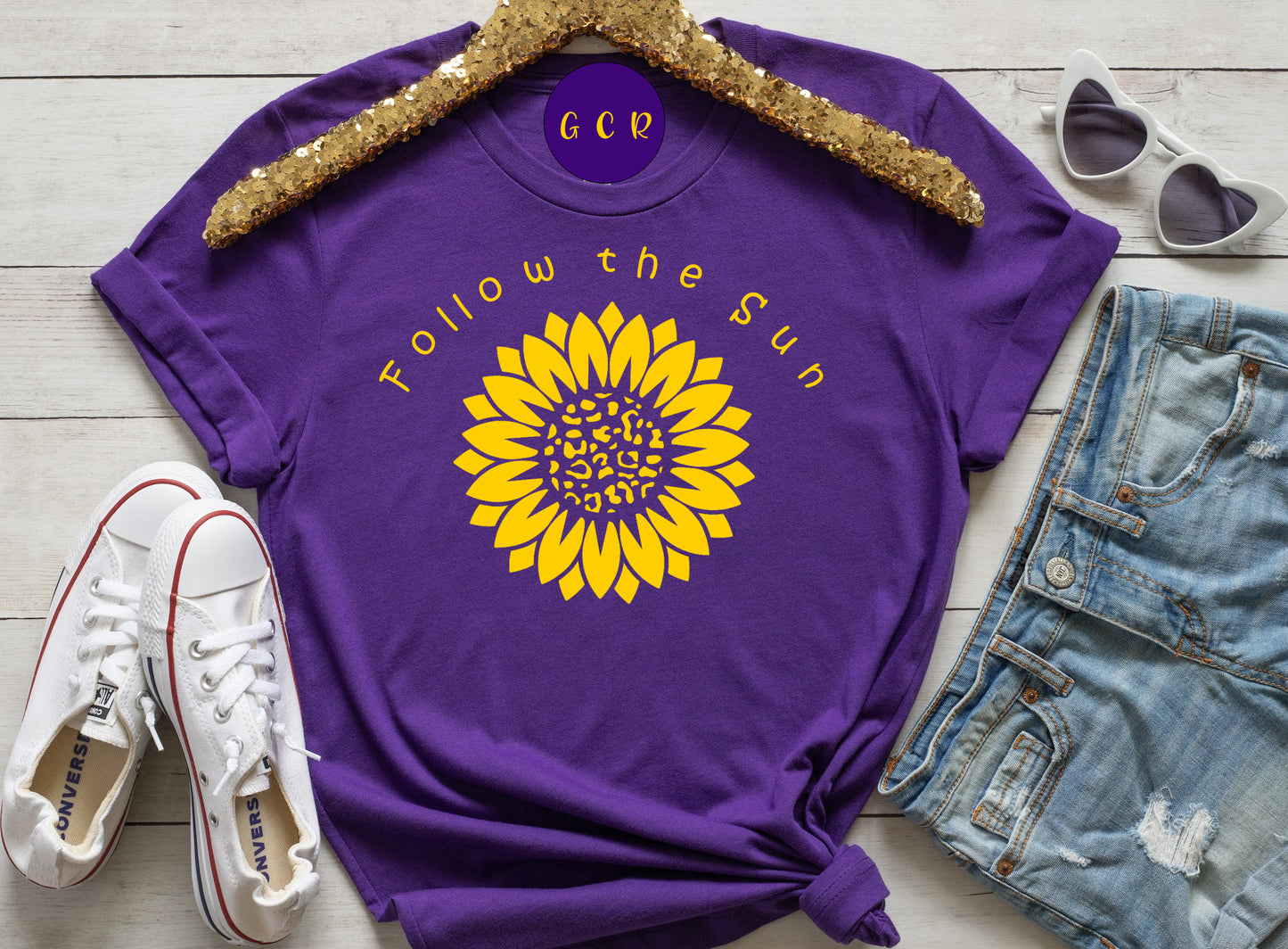 Purple short sleeve Tshirt with a yellow sunflower and the saying follow the sun in yellow
