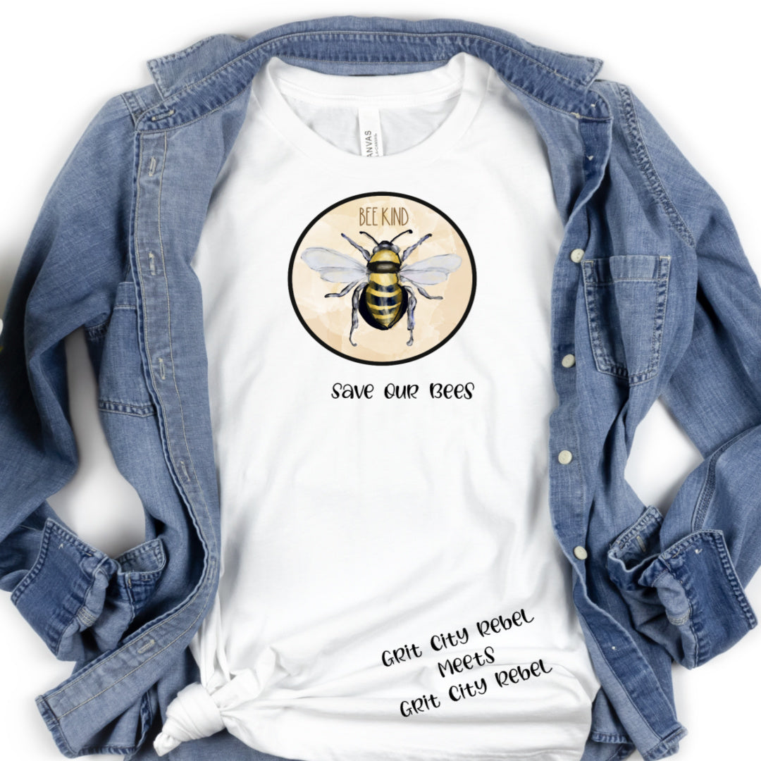White unisex T-Shirt, with Be Kind and a bee in a circle in color, and Save our bees under the circle in black writting.
