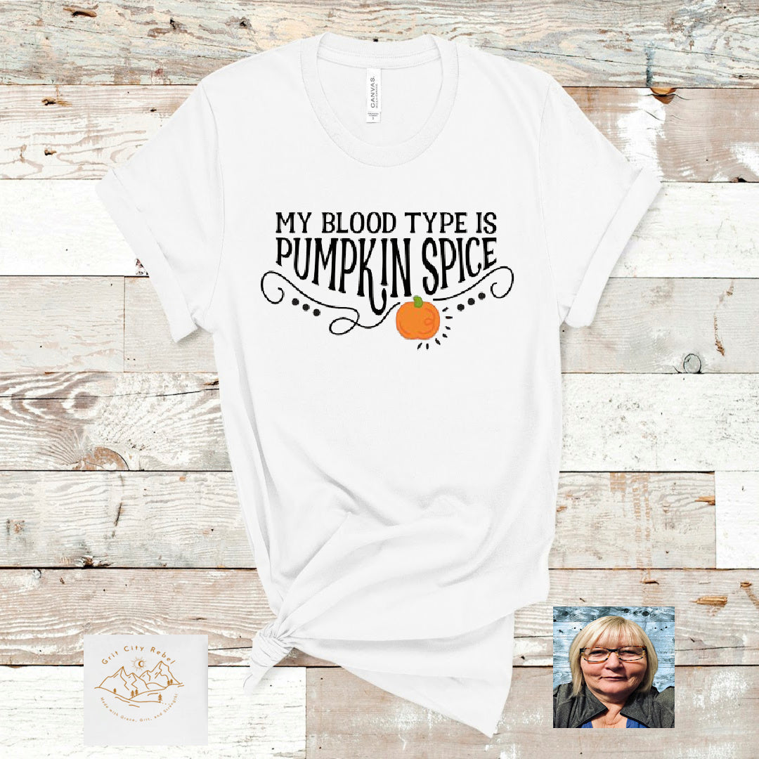 White TShirt with the saying My Blood Type Is Pumpkin Spice in black with a orange pumpkin. Grit City Rebel
