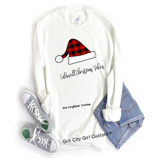 White long sleeve seatshirt crew neck with a Buffalo Plaid Santa Haat and can be personalized with your name