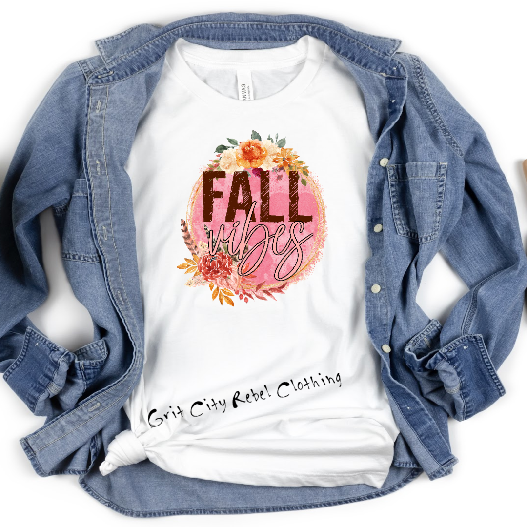 White Tshirt with a pink circle surounded by fall flowers and the words FALL Vibes across the circle 