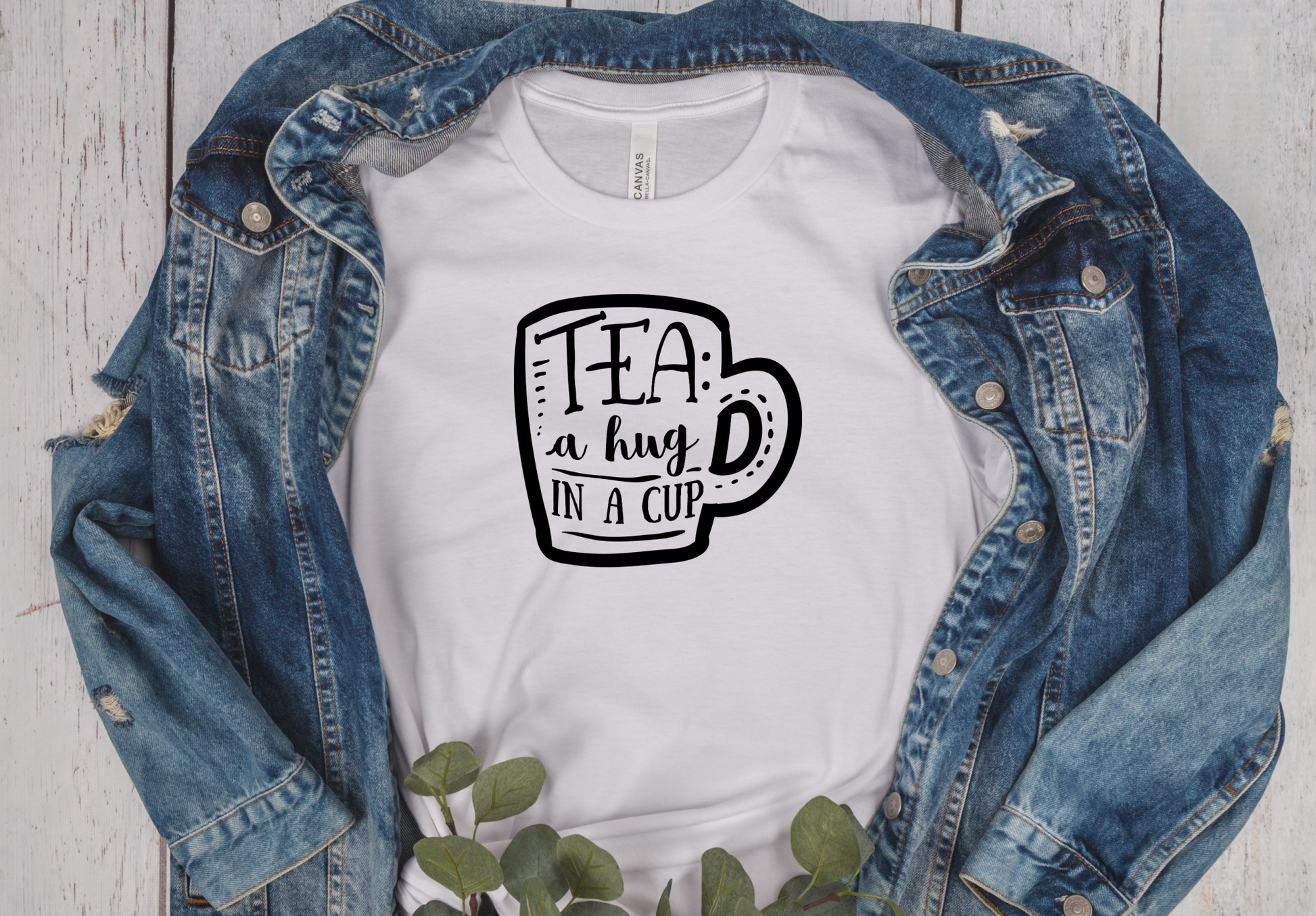 white short sleeve unisex T-Shirt with the graphic of a mug and the saying Tea is a hug un a cup