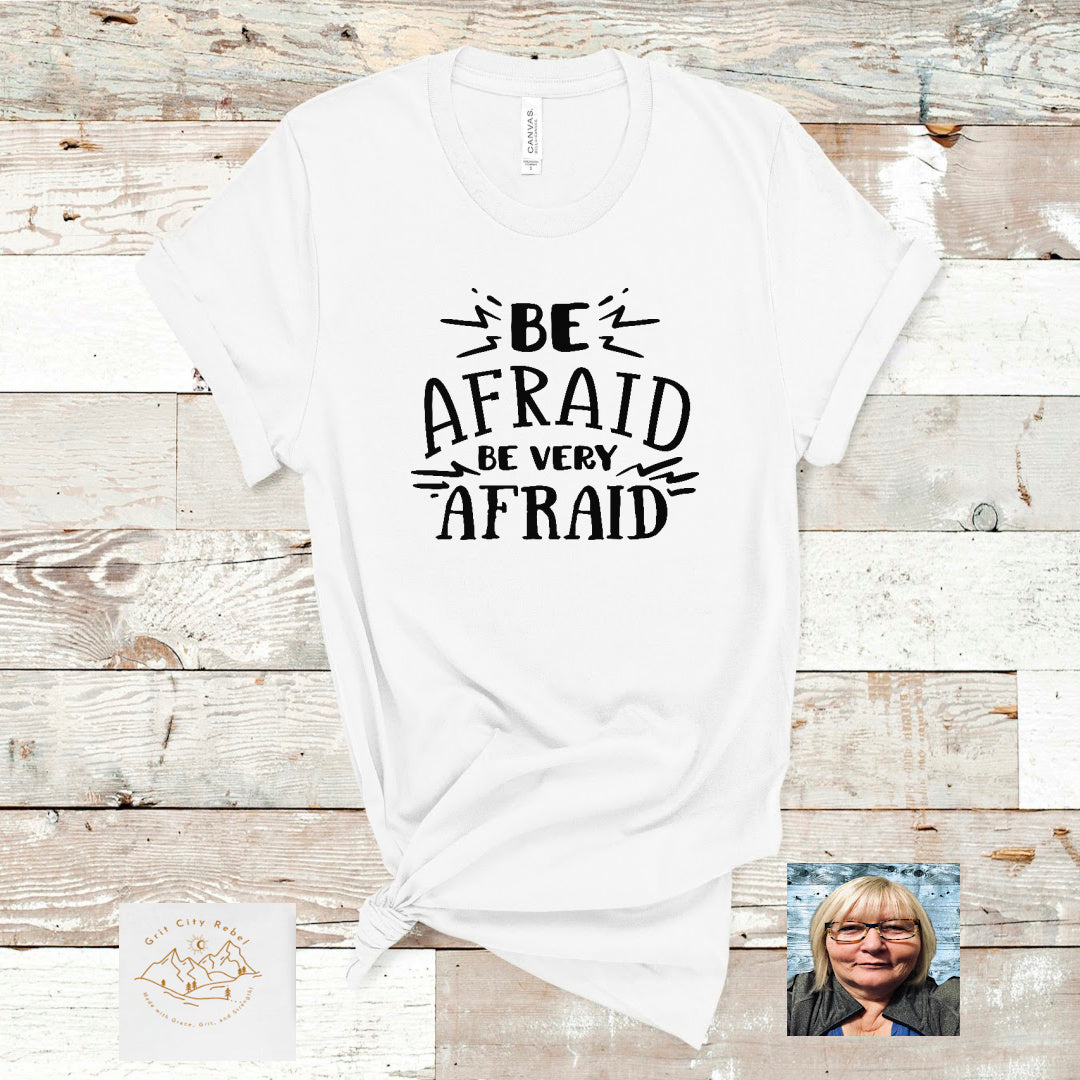 white short sleeve unisex T-Shirt with the saying Be Afraid very Afraid in black