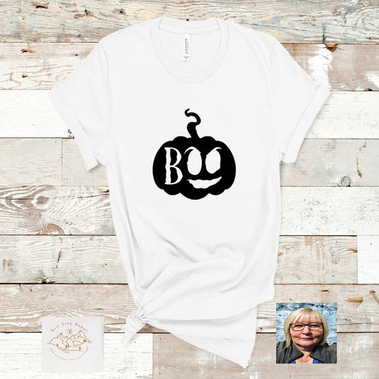 white short sleeve unisex Tshirt wuth a black pumpkin and the word BOo cut out of the pumpkin