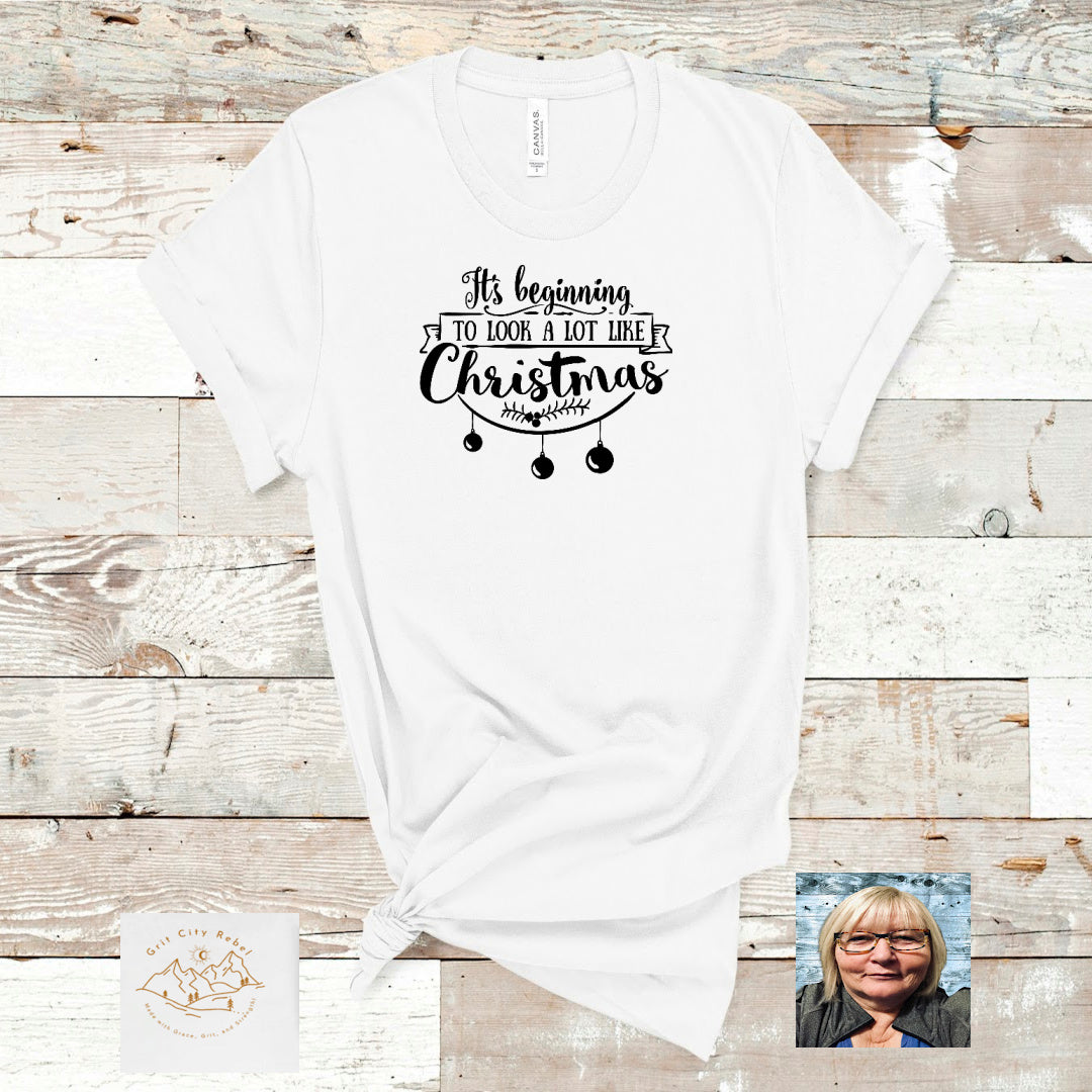 White short sleeve T-Shirt with the saying 'It's beginng to Look A Lot Like Christmas in Black writing.