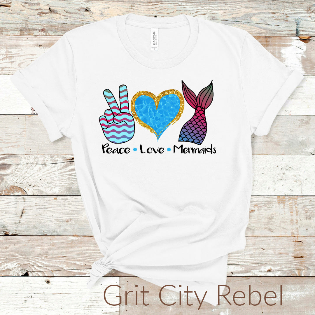 White unisex T-Shirt with Peace sign in blue and pink strips, Love heart in blue with glitter look outlineon the top, Mermaid tail in shades of pink, blue and black outline of scales.